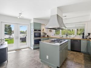 a kitchen with blue cabinets and a stove top oven at Bayside The Point in Saint Michaels