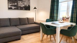 a living room with a couch and a table and chairs at Ruhige Ferienwohnung am Fürst-Pückler-Park, Sauna im Haus & Parkplatz Bad Muskau in Bad Muskau