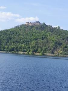 a mountain with a castle on top of a lake at het appeltje in Waldeck