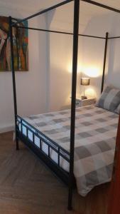 a bedroom with a four poster bed with a checkeredkered mattress at het appeltje in Waldeck