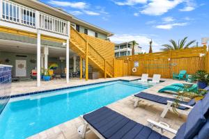a swimming pool with chairs and a house at Pet Friendly Beachfront Home - Casa Bella Del Sol in Cape San Blas