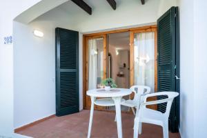 a white table and chairs on a patio at Complejo turístico Menorca SOL ISLA in Arenal d'en Castell