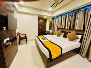 a bedroom with a bed and a red chair at Hotel Silver Seven in Jāmb +41 photos