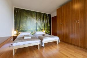 a bedroom with two beds and a large painting on the wall at ROSSO DI SERA Bed & Breakfast in Tarcento