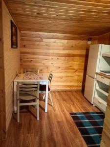 a small kitchen with a table and a refrigerator at Дом у моря in Suurupi
