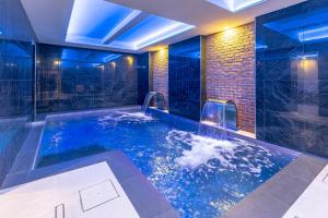 a jacuzzi tub in a bathroom with blue lighting at Hotel Master in Brescia