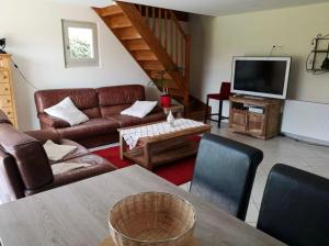a living room with a couch and a tv at Gite le Martalou in Lacapelle-Viescamp