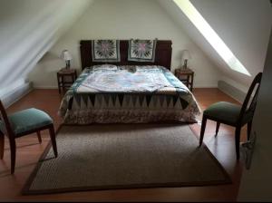 a bedroom with a bed and two chairs at Gite le Martalou in Lacapelle-Viescamp