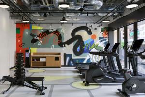 a gym with cardio machines and a colorful wall at Caption By Hyatt Kabutocho Tokyo in Tokyo