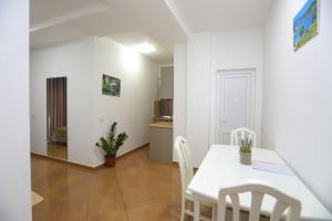 a kitchen and dining room with a white table and chairs at Hotel SUNSET GL in Vlorë