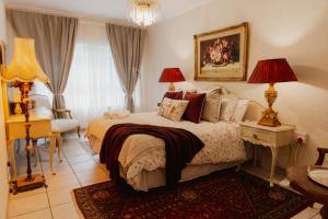a bedroom with a bed and a chair and a window at The Hidden Garden Guesthouse in Meyerton