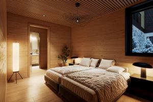 a bedroom with a large bed in a wooden wall at TAHKO LAKESIDE VILLA D 3 in Tahkovuori