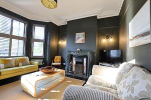 a living room with a couch and a fireplace at Suffolk Coast Townhouse in Pakefield