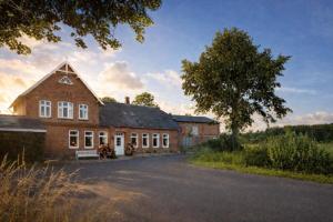 a large brick building with a tree in front of it at Atelier - Flensburger Förde in Westerholz