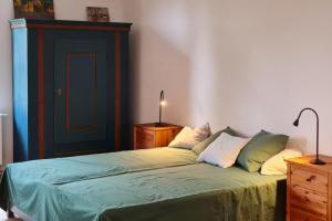 a bedroom with a bed with green sheets and pillows at Atelier - Flensburger Förde in Westerholz