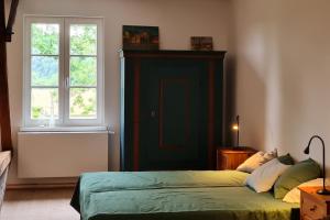 a bedroom with a green bed and a window at Atelier - Flensburger Förde in Westerholz