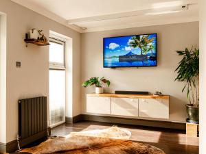 a living room with a tv on the wall at Sun Set House With Hot Tub in Witchford