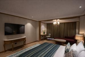 a hotel room with a bed and a flat screen tv at AB's Abode-A Boutique Hotel in Mussoorie +35 photos
