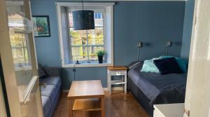 a room with a bed and a couch and a window at Charmig lägenhet nära Smögenbryggan in Smögen