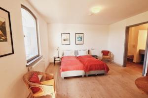 a bedroom with a bed with a red blanket at Kiekut's Land in Westerholz