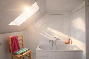 a bathroom with a bath tub and a skylight at Lake View - Flensburger Förde in Westerholz
