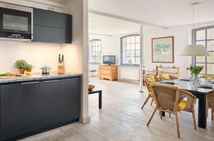 a kitchen and living room with a table and chairs at Rose Garden - Flensburger Förde in Westerholz