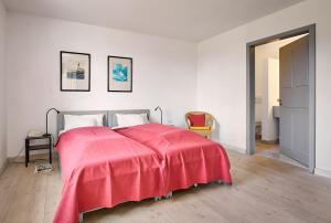 a bedroom with a bed with a red blanket on it at Rose Garden - Flensburger Förde in Westerholz