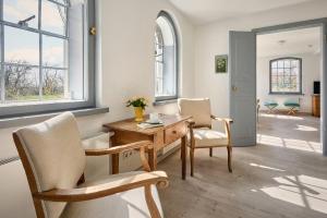 a living room with a wooden table and two chairs at Rose Garden - Flensburger Förde in Westerholz +13 photos