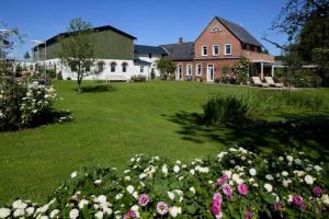 a large yard with flowers in front of a house at Rose Garden - Flensburger Förde in Westerholz