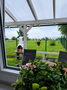 a patio with a table and chairs and a grill at Domki 7 Houses Rewal in Rewal