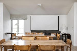 a classroom with tables and chairs and a projection screen at Ostseehof-Kernhof in Pommerby