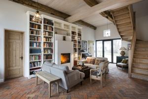 a living room with a fireplace and bookshelves at Ostseehof-Kernhof in Pommerby