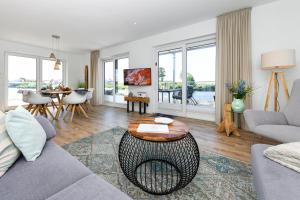 a living room with a couch and a table at Seeperle Meerleben in Carolinensiel +101 photos