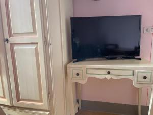 a flat screen tv on a white table next to a door at Casa Bicocchi in Lanciole