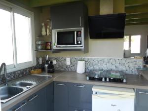 a kitchen with a sink and a microwave at Villa Soulacaise V in Soulac-sur-Mer +14 photos