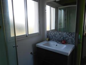 a bathroom with a sink and a mirror and a window at Villa Soulacaise V in Soulac-sur-Mer
