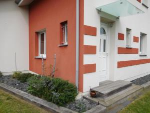 a house with orange and white walls and a door at Villa Soulacaise V in Soulac-sur-Mer