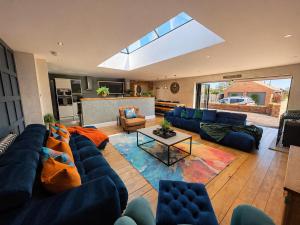 a living room with a blue couch and a table at The Stables Luxury House with Hot tub in York