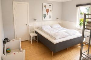 a small bedroom with a bed and a chair at Only 150 m to the nearest lake and 2,5 km to the top of Isaberg in Hestra