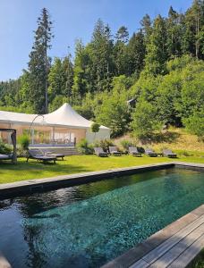 a swimming pool in a yard with a tent at Hrad Kunzov Boutique Hotel & SPA & Restaurant in Radíkov