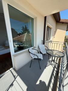 a balcony with a table and chairs and a window at Gradina in Chernomorets