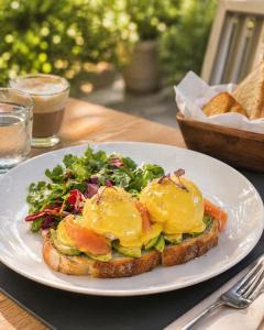 a white plate with a sandwich with eggs on it at Shkoder City Center - Floir Hotel in Shkodër