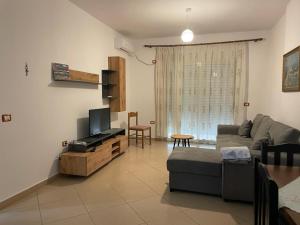 a living room with a couch and a tv at Endi Apartments 2 in Tirana