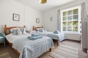 a bedroom with two beds and a window at Coastguards in Southwold
