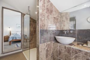 a bathroom with a glass shower and a sink at Coastguards in Southwold +24 photos