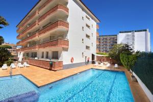 a swimming pool in front of a building at Apartamentos Eldorado in Lloret de Mar