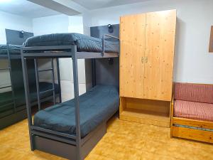 a room with two bunk beds and a wooden cabinet at Apartamentos Midi 3000 in Formigal