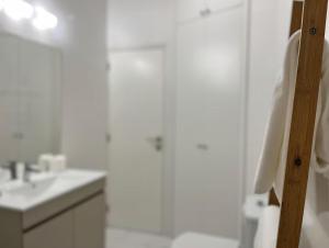 a white bathroom with a shower and a sink at Salt Beach Apartments B in Viana do Castelo