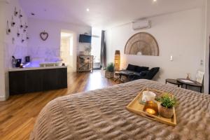 a bedroom with a bed with a tray on it at Le Carpe Diem - Détente & Bien-être - Balnéo, Sauna, CLIM, Terrasse, Parking privé in Dole
