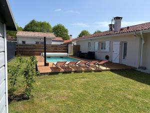 a backyard with a deck and a swimming pool at Suite indépendante avec piscine proche Océan in Saint-Vincent-de-Tyrosse
